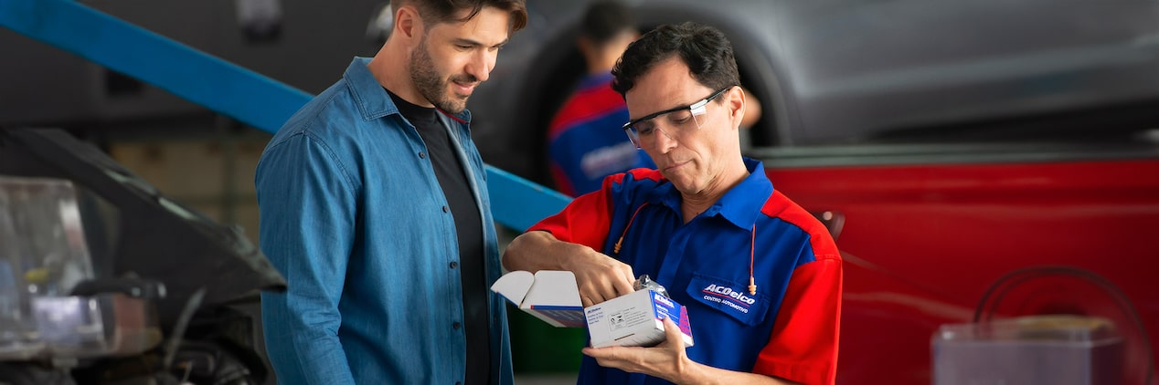 Mecânico mostrando um produto Acdelco para um cliente