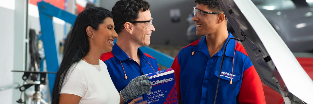 2 mecânicos e uma cliente conversando na Acdelco