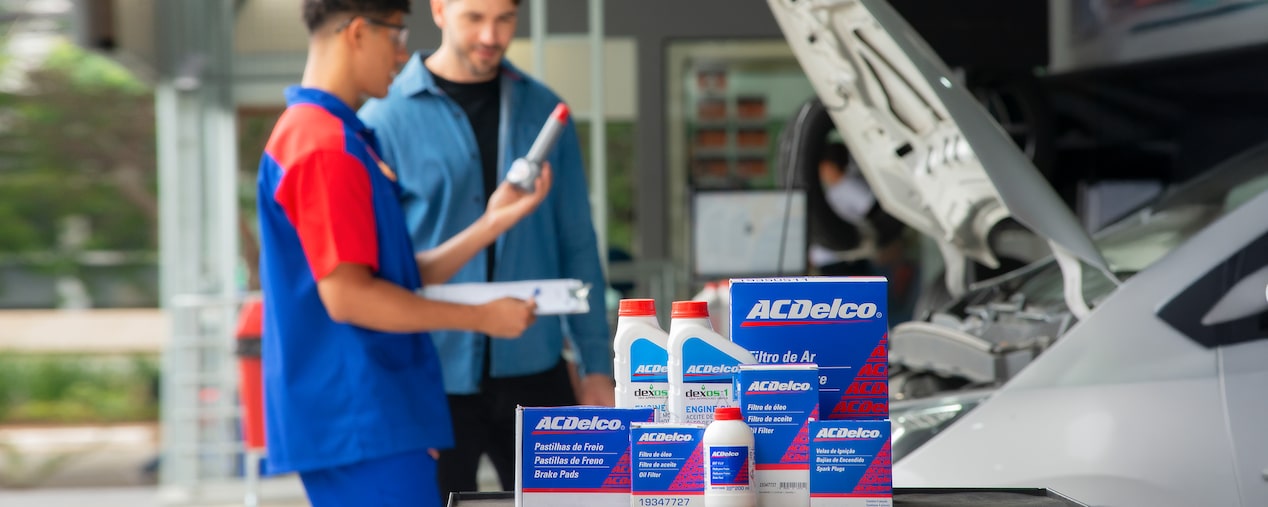 Productos ACDelco como filtros, aceites y pastillas exhibidos en taller mecánico.