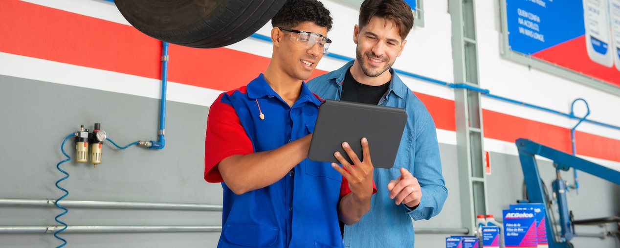Mecánico con cliente revisando diagnóstico en tablet en taller ACDelco.